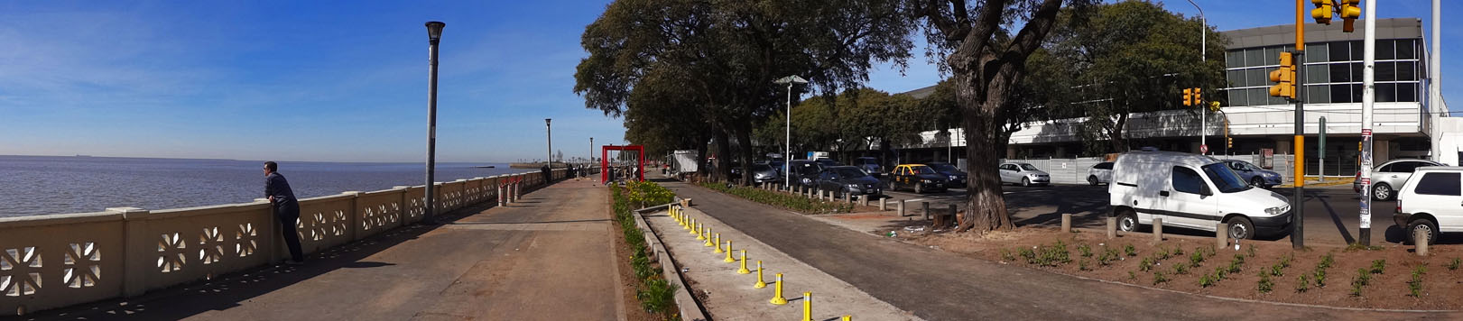 View of the riverwalk along the Rafael Obligado Riverfront Drive; one of the Jorge Newbery Airport terminals is visible at right.